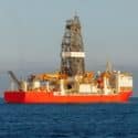 offshore oil and gas drillship in the open sea at sunset