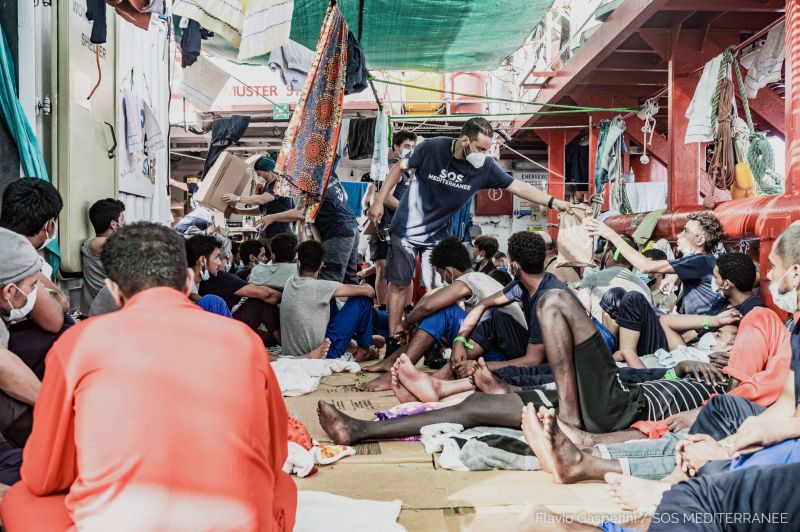 Overcrowding Conditions Onboard the Ocean Viking - recued migrants sitting on the floor as they are provided with basic amenities by SOS MEDITERRANEE