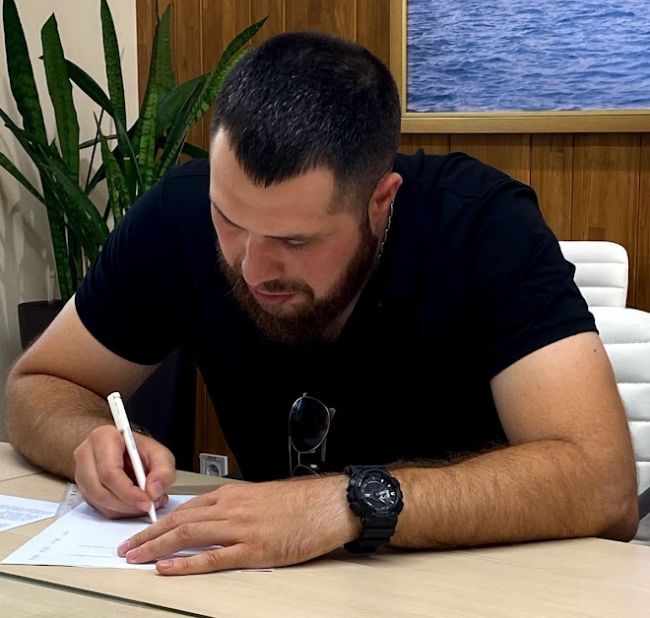 Yevgeniy Nikolov signs the final compensation​ agreement in the MTWTU office (Credit: MTWTU)​