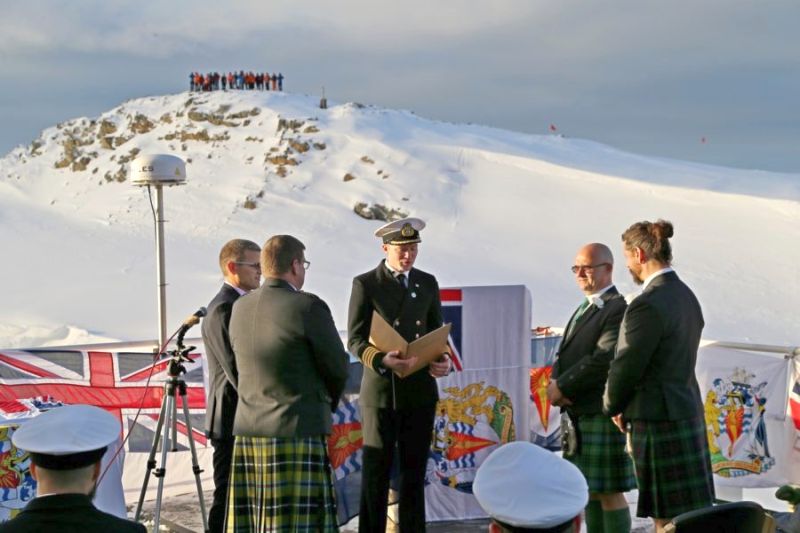 Ship Captain Will Whatley reads the nuptials to Eric (left) and Steve, with staff from Rothera Research Station in the background.
